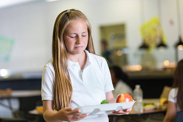 School girl upset about school food on lunch tray